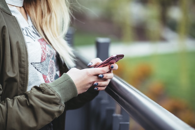 Kvinna som håller i en telefon